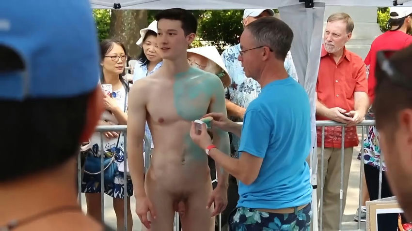 Naked handsome man acts as a model for an artist to paint his body